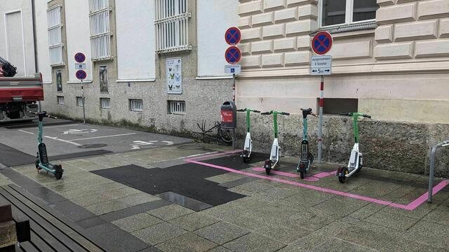 Pink markierte Abstellfläche für E Scooter vor einem Gebäude