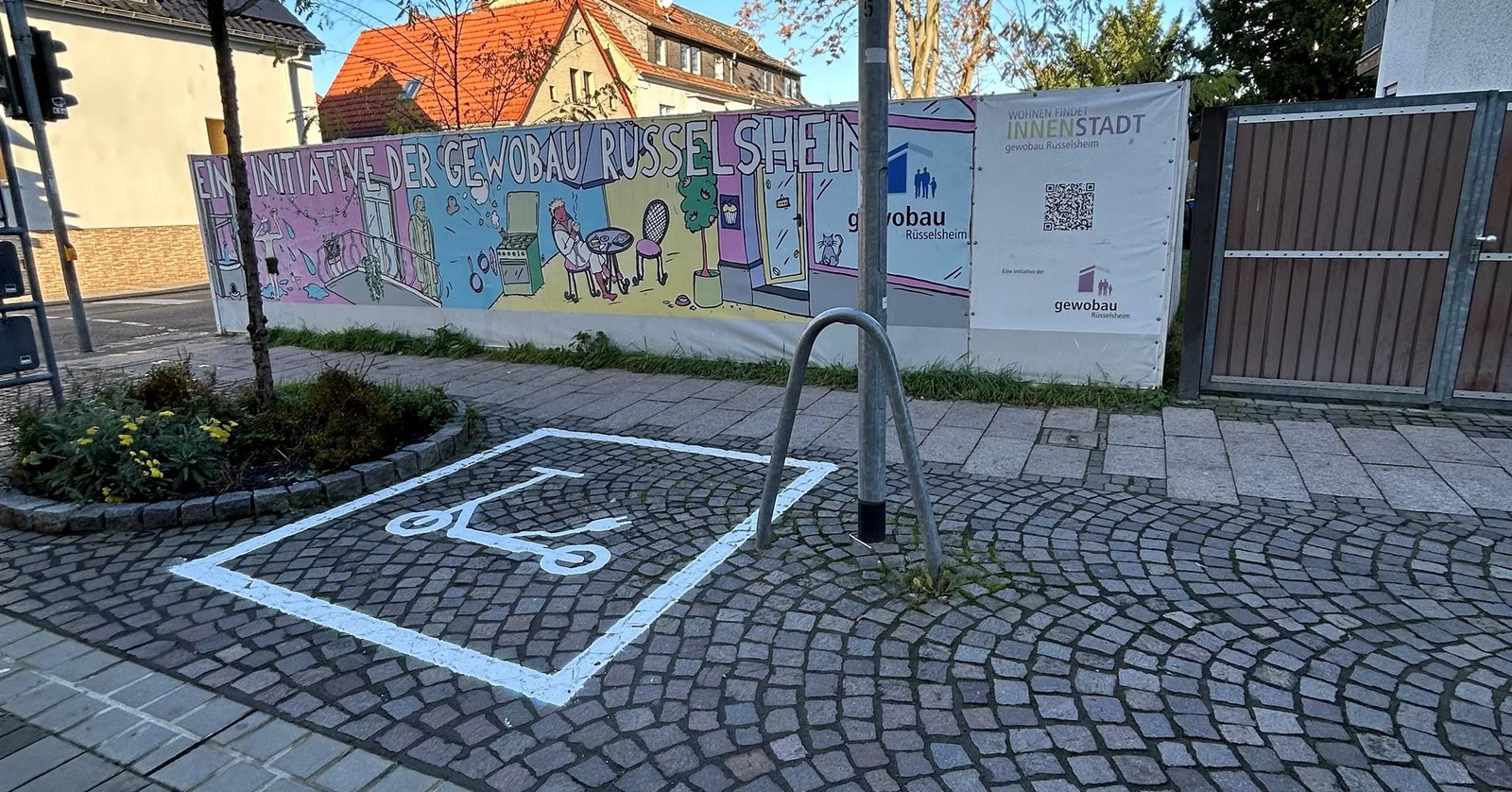Weiß aufgemalte Abstellfläche für E Scooter auf Kopfsteinpflaster