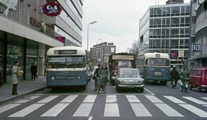 Straßenszene in Utrecht in den 1970er Jahren: Busse, Autos und eine Radfahrerin dazwischen