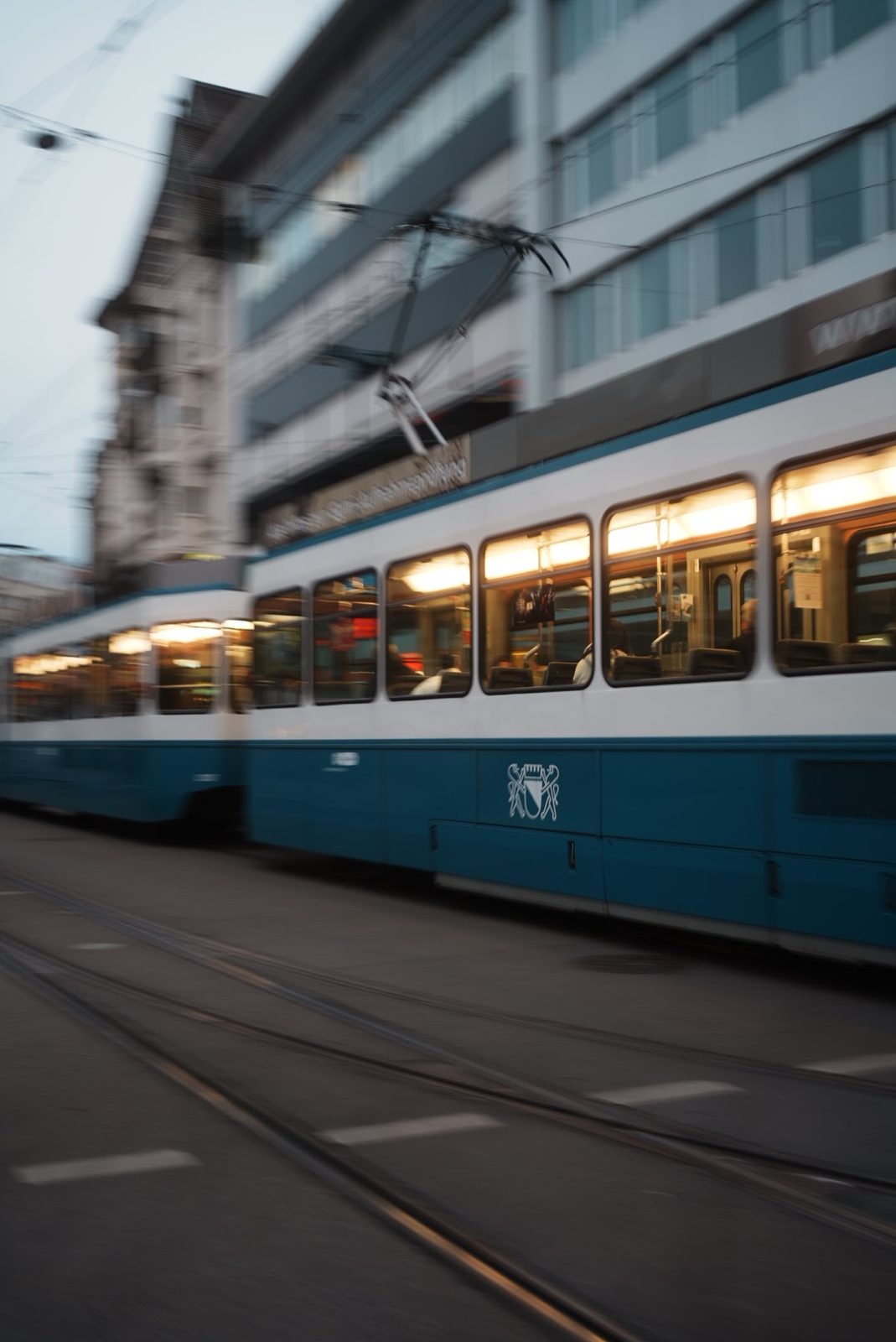 Blau weiße Zürcher Tram fährt schnell vorbei, Bewegungsunschärfe