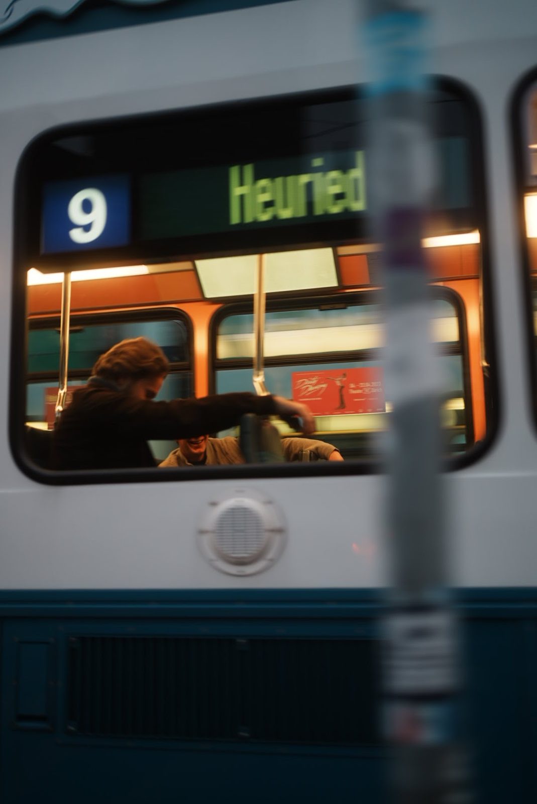 Blick durch das Fenster einer Zürcher Tram, Linie 9 nach Heuried, Fahrgäste lachen